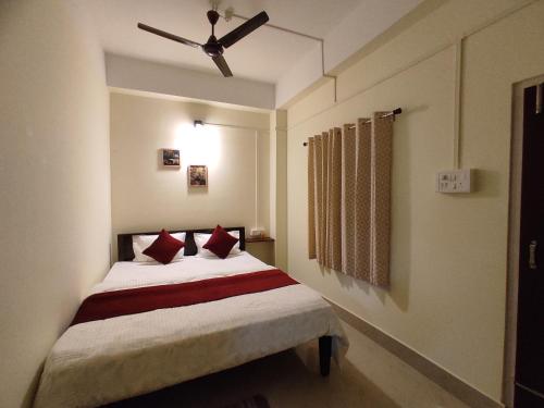 1 dormitorio con 1 cama y ventilador de techo en THE STAY CORNER en Guwahati