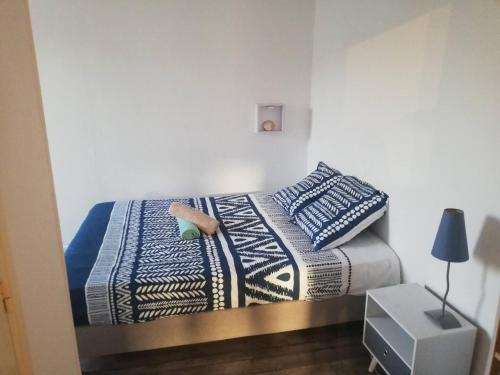 - une chambre avec un lit doté de couvertures et d'oreillers bleus et blancs dans l'établissement Petit appartement proche de la gare, à Brest
