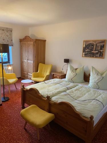 a bedroom with a bed and two yellow chairs at Neues Haus - Berggasthof und Hotel in Kurort Oberwiesenthal