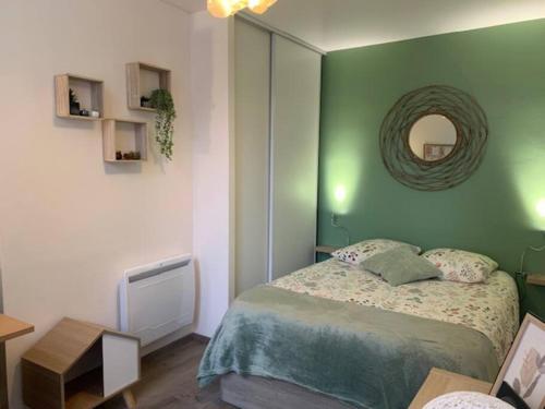 - une chambre verte avec un lit et un miroir dans l'établissement Etape saumuroise en centre-ville, à Saumur