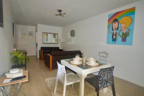 ein Wohnzimmer mit einem Tisch und einem Sofa in der Unterkunft Ideal family flat in st-ouen in Saint-Ouen