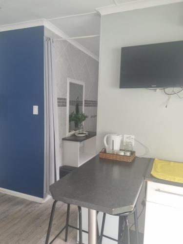 uma cozinha com uma mesa e um frigorífico azul em Eland Place Self Catering Guest House em Beacon Bay