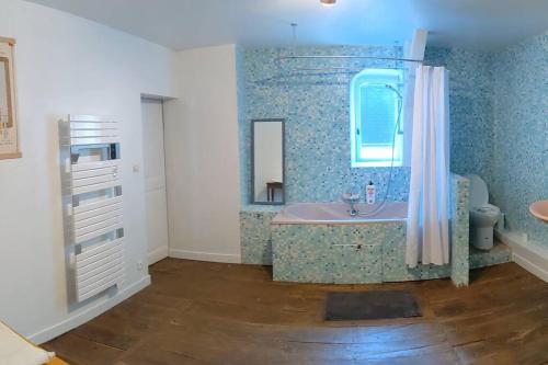 een badkamer met een bad en een wastafel bij Le Logis de Louis in Saint-Savin