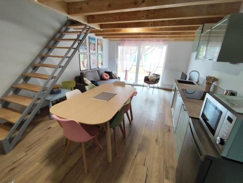 Il comprend une cuisine et un salon avec une table et un escalier. dans l'établissement Gîte indépendant au calme 