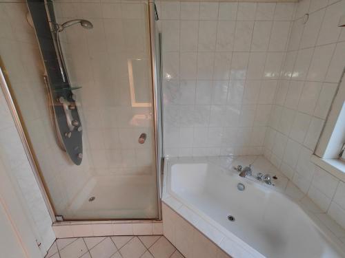 a bathroom with a shower and a bath tub at Gemütliches Haus mit schönem Garten in Vienna