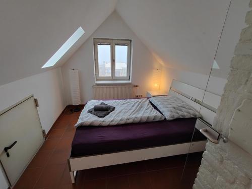 a small bedroom with a bed in a attic at Gemütliches Haus mit schönem Garten in Vienna