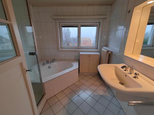 La salle de bains est pourvue d'une baignoire, d'un lavabo et d'une baignoire. dans l'établissement Gemütliches Haus mit schönem Garten, à Vienne