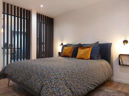 a bedroom with a bed with blue and yellow pillows at Urbs Amiens Sud in Amiens