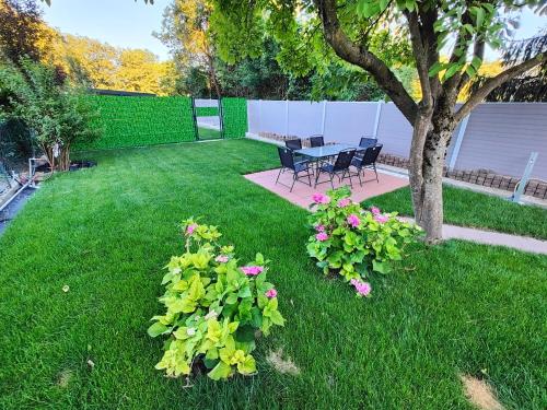 a yard with a table and chairs and flowers at Gemütliches Haus mit schönem Garten in Vienna