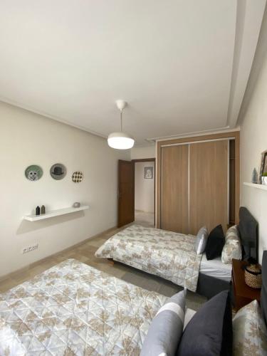 een slaapkamer met 2 bedden en een bank bij 2 Bedroom APT next to Casanearshore sidi maarouf in Casablanca