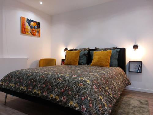 a bedroom with a large bed with yellow pillows at Urbs Amiens Sud in Amiens