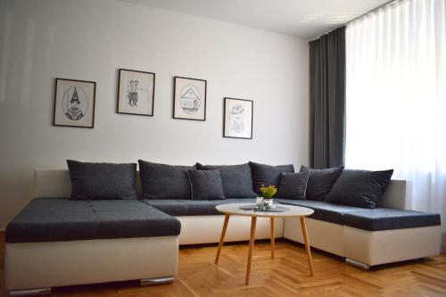 a living room with a couch and a table at BorLu apartman in Đakovo
