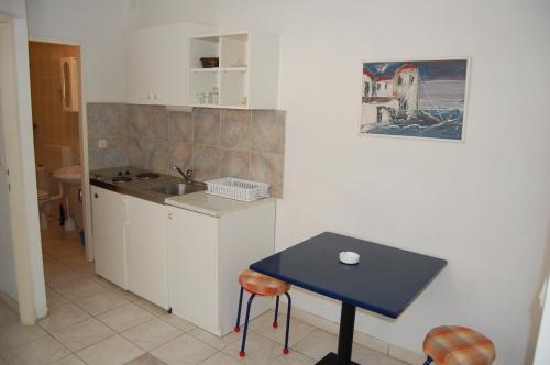 a small kitchen with a blue table and a sink at Apartment Kordić in Sveta Nedelja