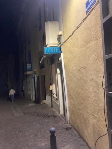 una calle con un cartel de la casa en el lateral de un edificio en Hostel auberge en Béziers