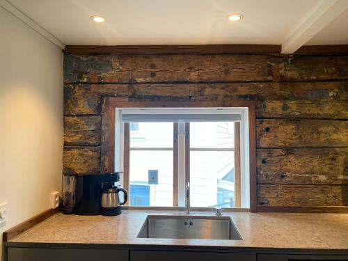 - une cuisine avec un évier et un mur en bois dans l'établissement Entire renovated apartment from 1780 with Kitchen, Bath, Bedroom, and Living Room in Skuteviken, à Bergen