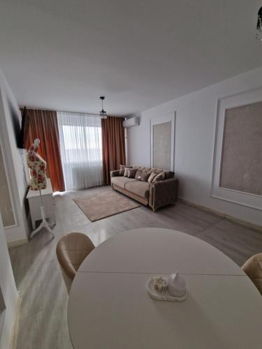 een woonkamer met een bank en een tafel bij Palace Hils in Boekarest