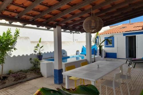 a white table and chairs on a patio with a pool at Casa Caridade in Reguengos de Monsaraz