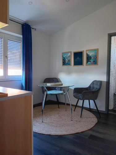 een woonkamer met een tafel en 2 stoelen bij Apartman Dunav in Vukovar