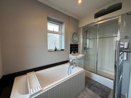 ein Bad mit einer Badewanne, einem Waschbecken und einer Dusche in der Unterkunft Quebec House - Free Parking and Wifi, 'Comfortable Spacious House Near to Town Centre in Swindon