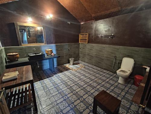 a bathroom with a toilet and a sink at Sea Front Cottage Little Khola in Cola
