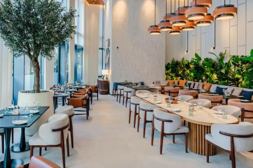 a restaurant with tables and chairs and plants at Vida Dubai Marina & Yacht Club, Hotel and Residences, Luxurious 2BR in Dubai