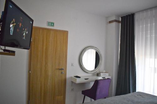 a room with a bed and a tv and a window at BorLu apartman in Ðakovo