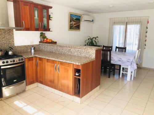a kitchen with a stove and a table with a dining room at Hermosa y Amplia Casa Familiar en Alta Gracia in Alta Gracia