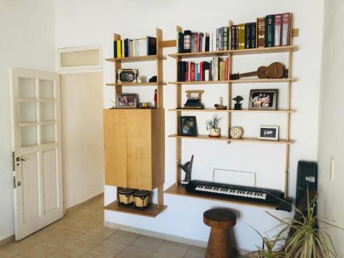ein Zimmer mit einer Tastatur auf einem Regal mit Büchern in der Unterkunft Hermosa y Amplia Casa Familiar en Alta Gracia in Alta Gracia