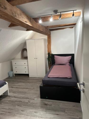 a bedroom with a bed and a white cabinet at Zur Scheune in Bad Wildungen