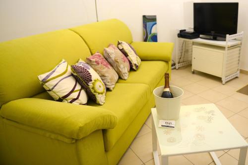 a yellow couch with pillows on it in a living room at B&B Affittacamere Del Teatro in Brindisi