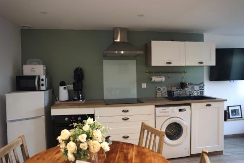 a kitchen with a table and a washer at Chez Marianne & Mathieu in Moustoir-Remungol