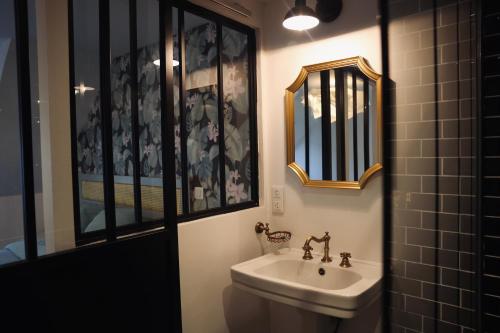 a bathroom with a sink and a mirror at Chez Marianne & Mathieu in Moustoir-Remungol