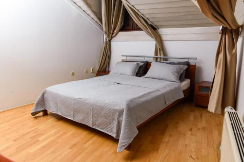 a bedroom with a large bed with a wooden floor at RESIDENTIAL HOUSE in Sarajevo