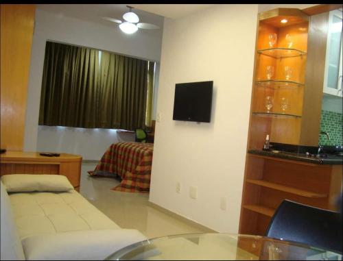 ein Wohnzimmer mit einem Sofa und einem TV an der Wand in der Unterkunft Blue Apartment Copacabana in Rio de Janeiro