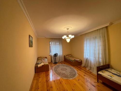 a living room with wooden floors and a large window at Quba Villa in Uçgün