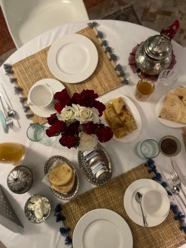a table with plates of food and a vase of flowers at RIAD DAR NAOMI in Marrakech