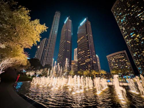 a water fountain in front of a city at night at The Address Residences Dubai Opera , Full Burj Khalifa View , Luxurious 2BR in Dubai