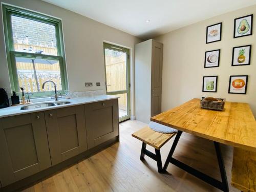 a kitchen with a sink and a wooden table at Luxurious Beach House Chesil Beach. Sleeps 6 in Castletown