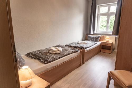 twee bedden in een kamer met een raam bij Apartmenthaus am Grienericksee in Rheinsberg