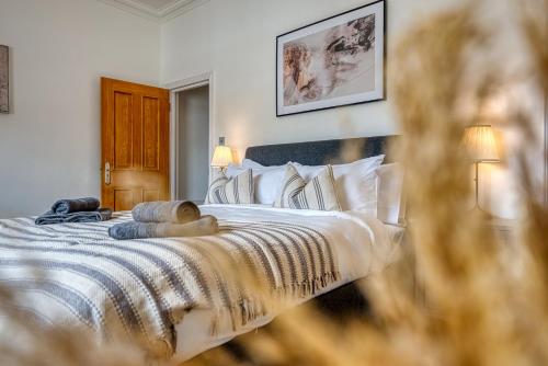 a bedroom with a bed with white sheets and pillows at 2-Bedroom Stunning, Modern & Spacious Apartment, near Ocean Village, Central Southampton - by Blue Puffin Stays in Southampton
