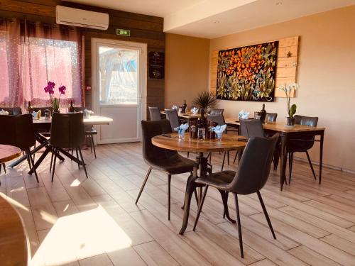 a restaurant with tables and chairs and a painting on the wall at Lodges du Ushuaïa Villages Camping les 4 Saisons in Grane