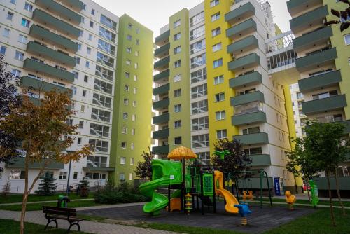 um parque infantil em frente a edifícios de apartamentos em JAD - Comfortable - Apartments - Coresi em Braşov