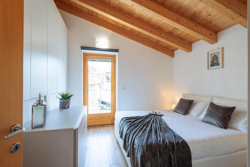 a bedroom with a bed and a television and a window at REVO Apartments - Cà Berti in Teglio