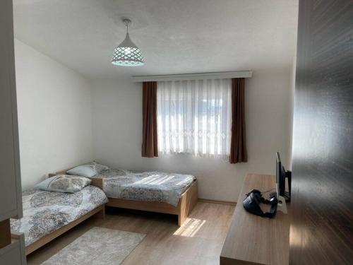 een slaapkamer met 2 bedden en een tafel en een televisie bij Central City Apartment in Pristina