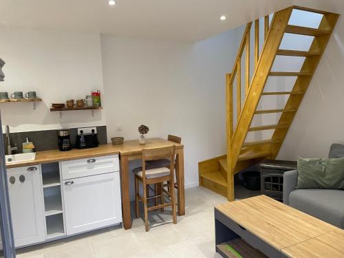 a kitchen with a desk and a staircase in a room at Les GITE st Nicolas La campagne a 5 min de la mer! in Camlez