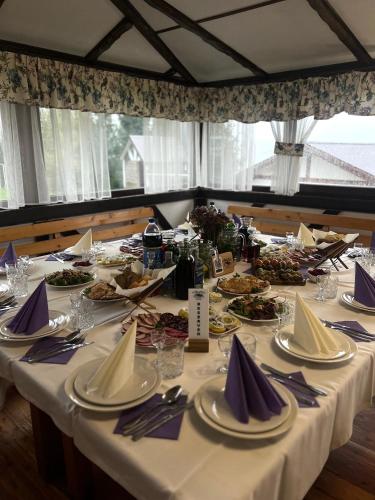 a long table with plates of food on it at Готельно-Ресторанний комплекс Кичера in Volovets