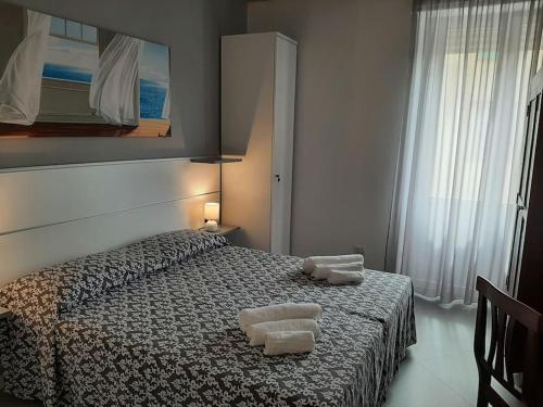 een slaapkamer met een bed met twee handdoeken erop bij Aleph Guest House relax a due passi dal mare in Fertilia