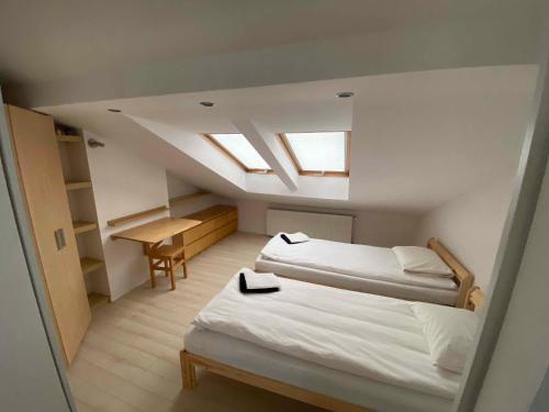 a attic bedroom with two beds and a desk at Kleine weisse Doppelhaushälfte in Częstochowa
