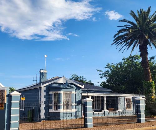 a blue and white house with a palm tree at Picanha Guesthouse in Heidelberg
