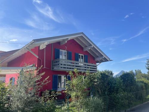 a red house with a balcony on top of it at Ferienwohnung Seidenhuhn in Kiefersfelden